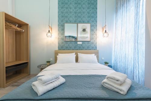 a bedroom with a large bed with towels on it at Plaka Akrokeramo House #1 in Athens