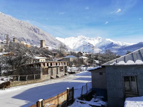 a snow covered town with mountains in the background at Guesthouse Mabu - 4 Newly Built Rooms in the Heart of Mestia in Mestia