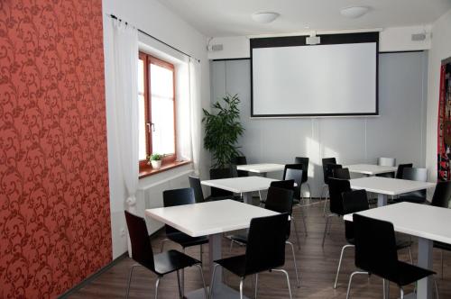 a room with tables and chairs and a projection screen at Penzion Pohanka in Nové Veselí