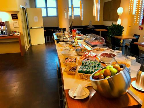 a long buffet of food on a table in a kitchen at HC3 Hotel in Bologna