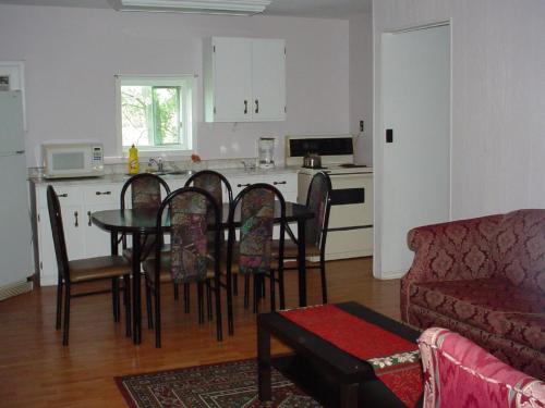 a living room with a table and chairs and a kitchen at Blue Moon Motel in Niagara Falls