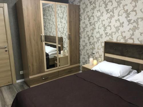 1 dormitorio con 1 cama grande y espejo en A Modern Suite Close to Gondola Ski Lift, en Bakuriani