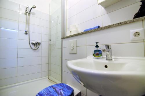 a white bathroom with a sink and a shower at Apartment Köln-Mülheim in Cologne