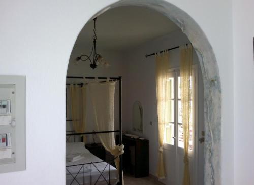 an archway in a room with a bed and a window at Giannakas Studios in Platis Yialos Sifnos