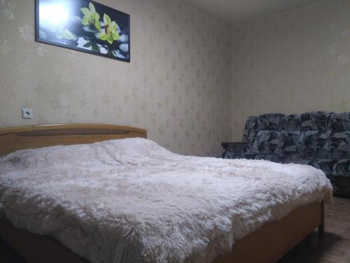 1 dormitorio con 1 cama y TV en la pared en Просторная 1комнатня квартира напротив ТРЦ Дафи Ашан рядом ресторан Альтбир, en Járkov