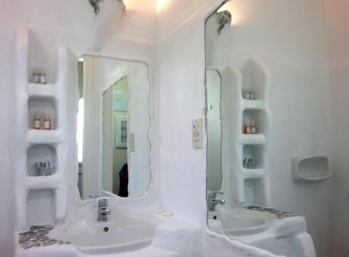 a white bathroom with two sinks and two mirrors at Giannakas Studios in Platis Yialos Sifnos
