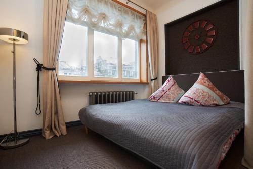 - une chambre avec un lit, une fenêtre et une horloge dans l'établissement Town Hall Apartments, à Vilnius