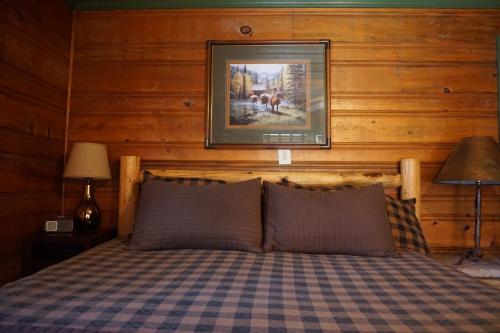 a bedroom with a bed with a picture on the wall at Shaver Lake Village Hotel in Shaver Lake