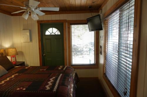 a bedroom with a bed and a tv and a window at Shaver Lake Village Hotel in Shaver Lake