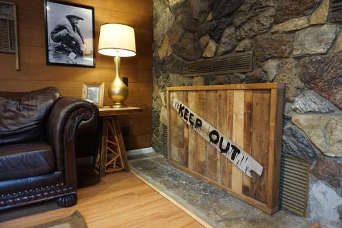 a living room with a couch and a stone wall at Shaver Lake Village Hotel in Shaver Lake
