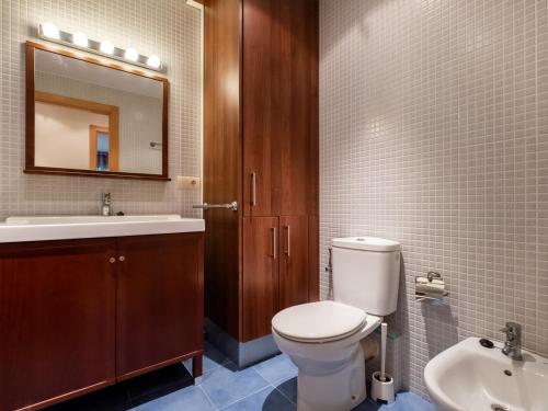 a bathroom with a toilet and a sink and a mirror at Stay Barcelona Maragall in Barcelona