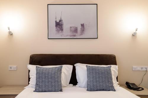 a bedroom with a bed with two pillows and a picture at Pensiunea Select Central in Târgu-Mureş