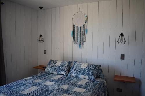 a bedroom with a bed with blue and white sheets at Morros del Pacífico in Pichilemu