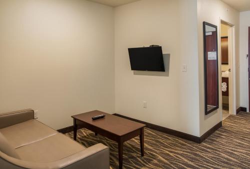 a room with a couch and a table and a tv at Cobblestone Inn and Suites - Ashland in Ashland
