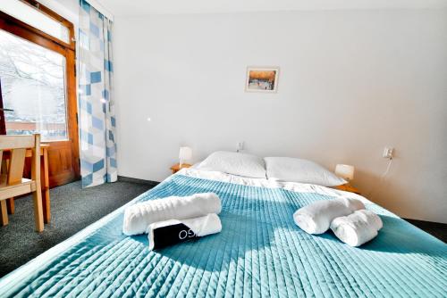 a bedroom with a large bed with towels on it at Panorama Gór w Karpaczu in Karpacz