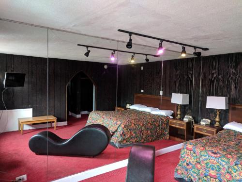 a hotel room with two beds and a black chair at Skylark Motel in Chicago