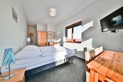 a bedroom with a bed and a desk and a television at Panorama Gór w Karpaczu in Karpacz