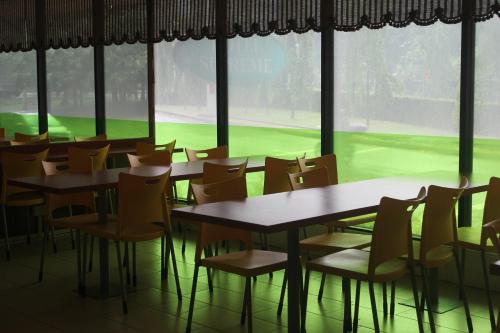 a room with tables and chairs in front of a window at Hotel Supreme in Singapore