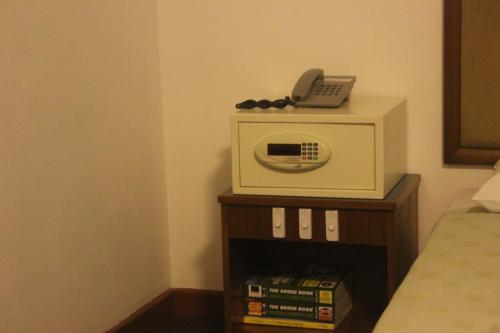 a room with a microwave with a phone on it at Hotel Supreme in Singapore