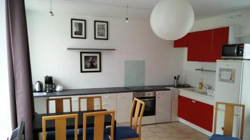 a kitchen with red and white cabinets and chairs at Les Fontaines in Baron