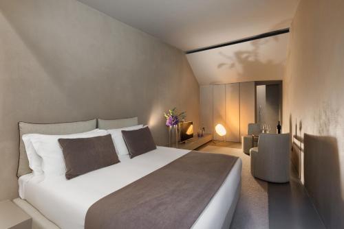 a bedroom with a large white bed and a table at Elysium Suites collection in Rome