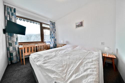 a bedroom with a white bed and a window at Panorama Gór w Karpaczu in Karpacz
