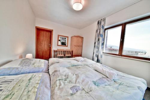 two beds in a bedroom with a window at Panorama Gór w Karpaczu in Karpacz
