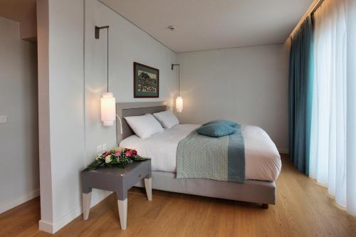 a bedroom with a bed and a table with flowers at Chios Chandris in Chios