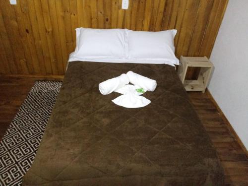 a bed with two rolls of toilet paper on it at Pousada Bica D'Água De frente BR 282 in Lages