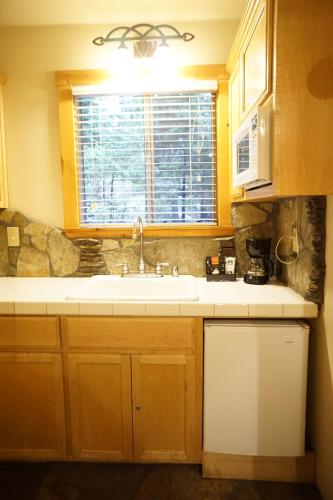 a kitchen with a sink and a window at Shaver Lake Village Hotel in Shaver Lake