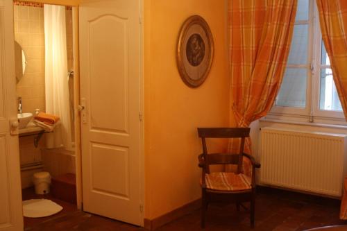 une salle de bain avec des toilettes, une chaise et une fenêtre dans l'établissement Domaine de Lamartine, à Pont-Saint-Esprit