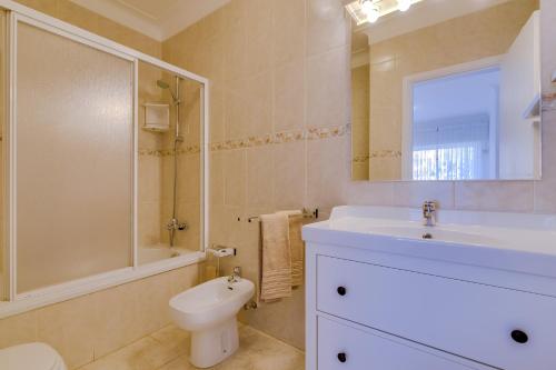 a bathroom with a sink and a toilet and a mirror at Ribas - Cozy 2 bedroom apartment - Vilamoura in Vilamoura