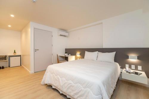 a bedroom with a large white bed with white pillows at Hotel Praia Bonita Jangadeiros Pajuçara in Maceió
