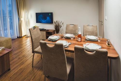 a dining room table with chairs and a bottle of wine at Magic Tatry, Primo Starý Smokovec in Starý Smokovec