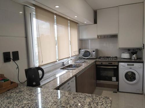 a kitchen with a sink and a washing machine at Apartamento 46 in Necochea