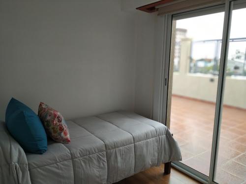 a couch in a room with a sliding glass door at Apartamento 46 in Necochea