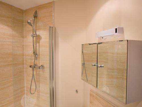 a shower in a bathroom with a glass shower stall at The Old Forge, Trafalgar Court in York