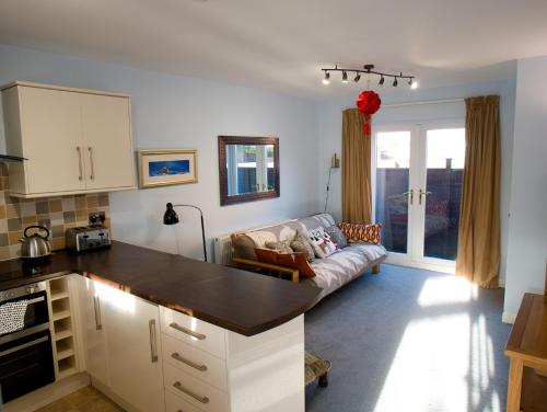 a kitchen and a living room with a couch at The Old Forge, Trafalgar Court in York