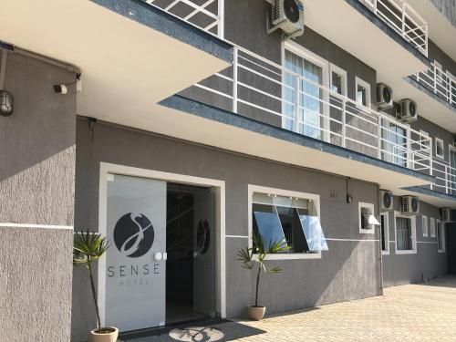 a building with a sign on the side of it at Sense Flat Hotel in Araucária