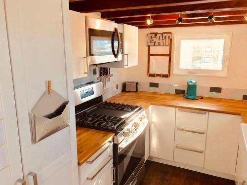 a kitchen with white cabinets and a stove top oven at Tiny House Leadville Colorado in Leadville