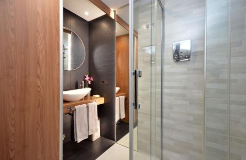 ビーゴにあるSUITE DE LUJO-CENTRO Kilometro 0-PARKINGのバスルーム(ガラス張りのシャワー、シンク付)