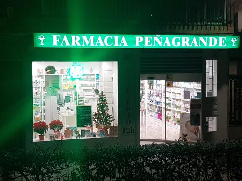 a store front with a green sign on it at Bonito Apto Barrio del Pilar Smart Fit in Madrid