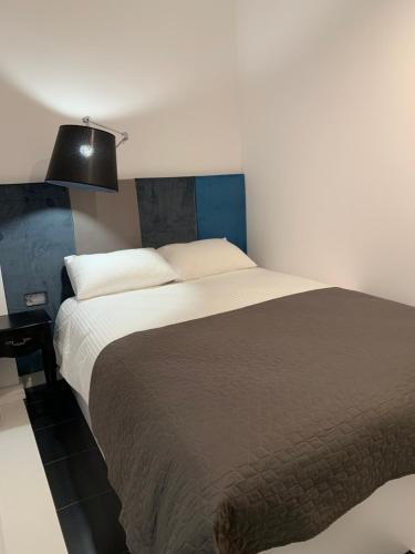 ビャウィストクにあるD&M Apart Suraska 4のベッドルーム(大型ベッド1台、ブラックランプ付)