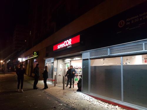 a group of people standing outside of a store at night at Bonito Apto Barrio del Pilar Smart Fit in Madrid