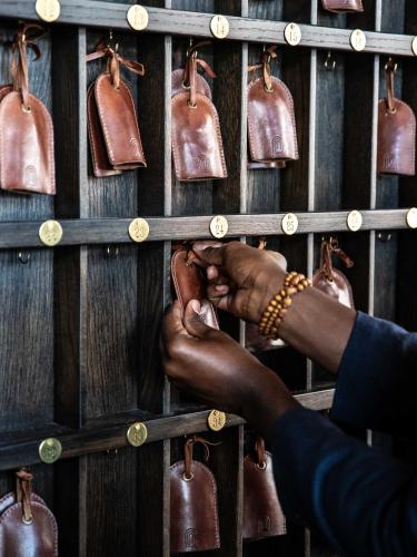 a person holding onto a rack of leather bags at The Ramble Hotel in Denver