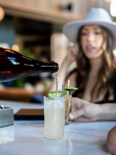 a bottle of wine being poured into a drink at The Ramble Hotel in Denver