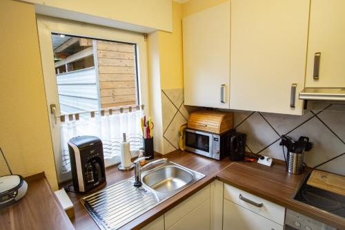 a kitchen with a sink and a microwave at Ferienwohnung Behner in Greven