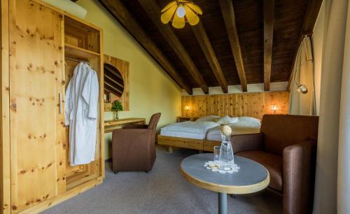 a bedroom with a bed and a table in a room at Sporthotel Walliserhof in Unterbäch
