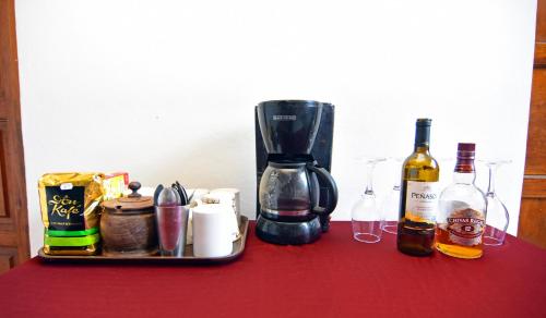 サンミゲルにあるHotel Europaのテーブル、コーヒーメーカー、ワインボトル