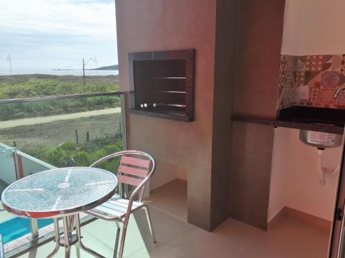 a balcony with a table and chairs and a window at Beira Mar Village in Pinheira